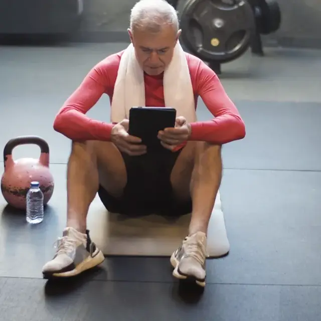 A member checking their plan on a tablet between sets